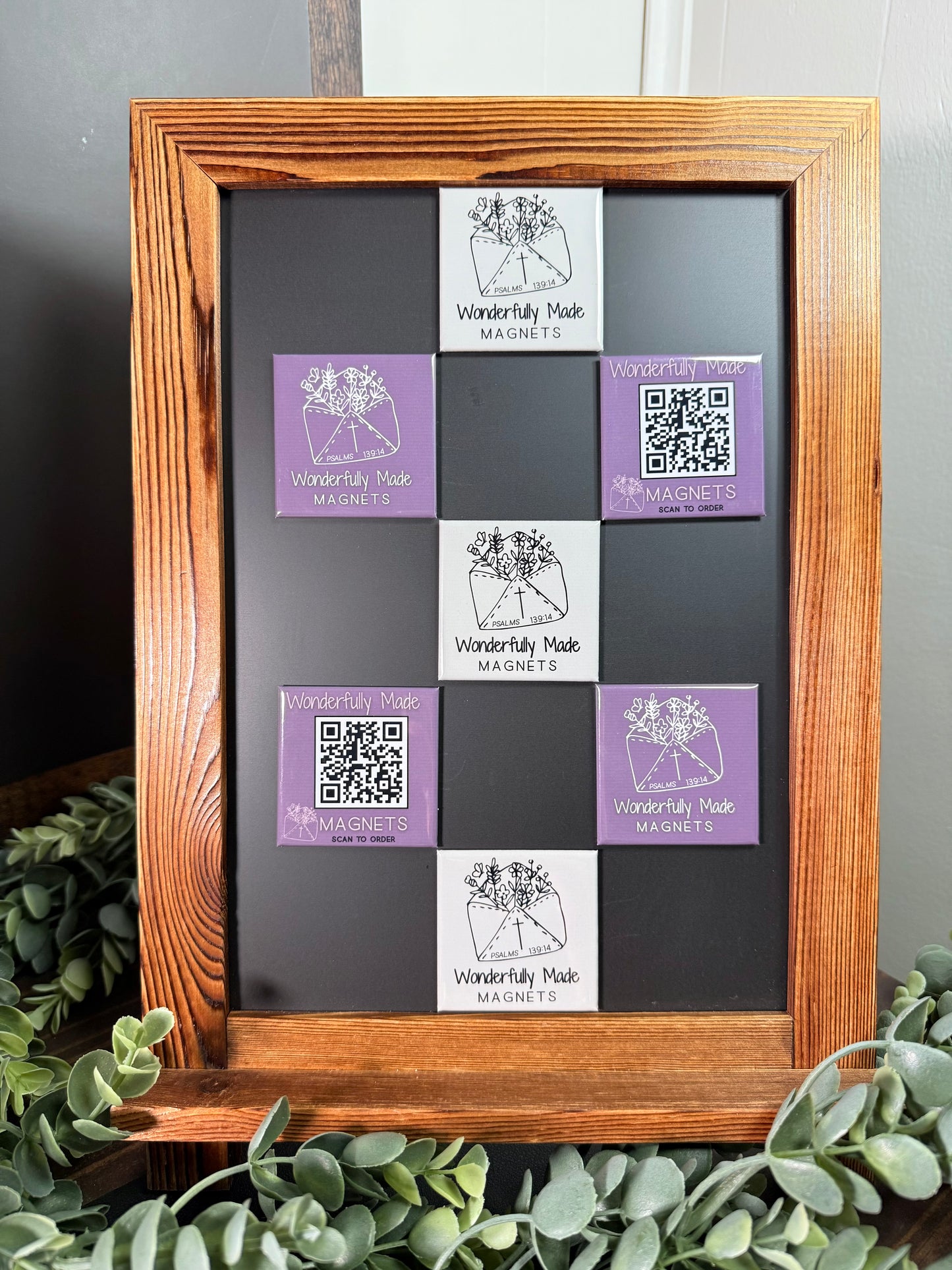 Collection of 2x2 custom branded magnets for Wonderfully Made Magnets on a magnetic board