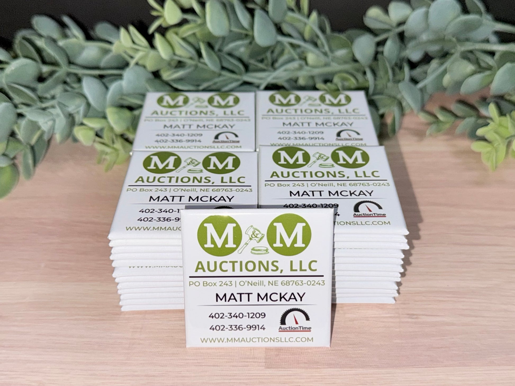 Stack of 2x2 custom business logo magnets for bulk ordering.