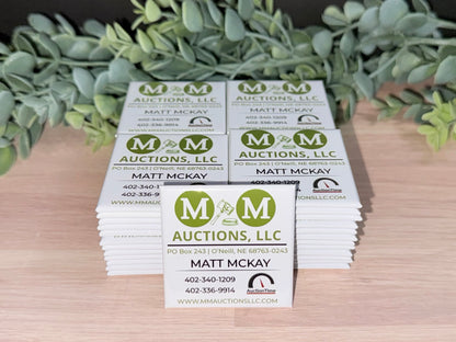 Stack of 2x2 custom business logo magnets for bulk ordering.
